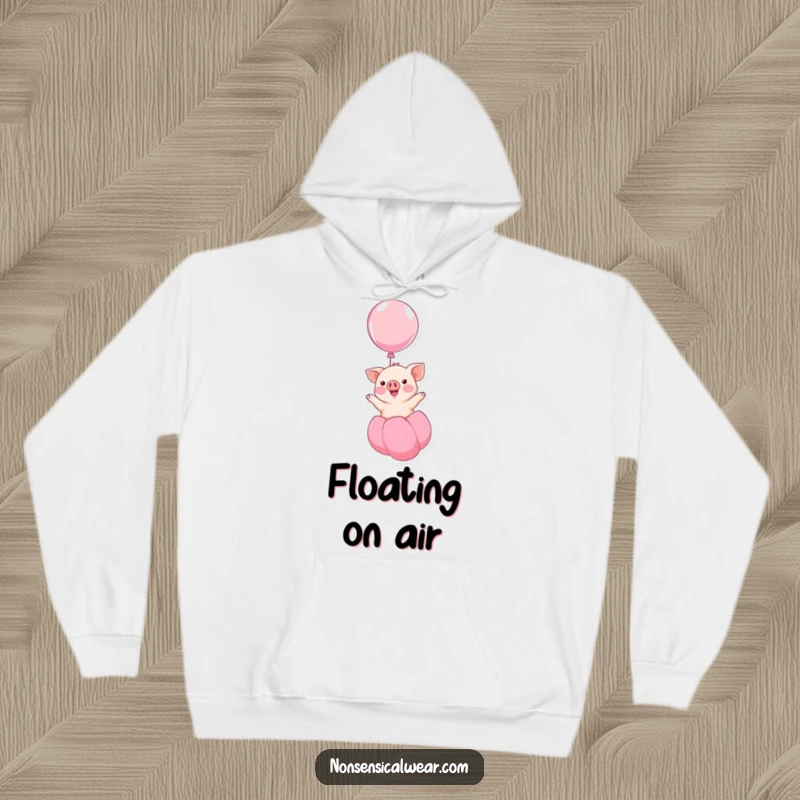 Funny kawaii piglet smiling and floating upwards on a balloon, a humorous and cozy design on this hoodie, perfect for relaxation.
