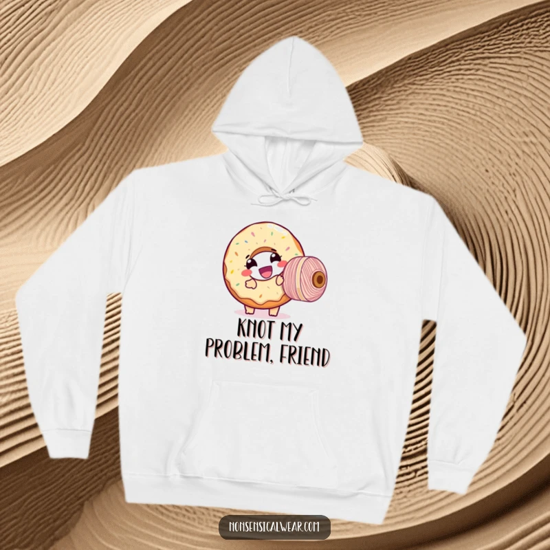 Funny hoodie depicting a giggling donut character hilariously tangled with a giant spool of thread, offering warmth and humor.