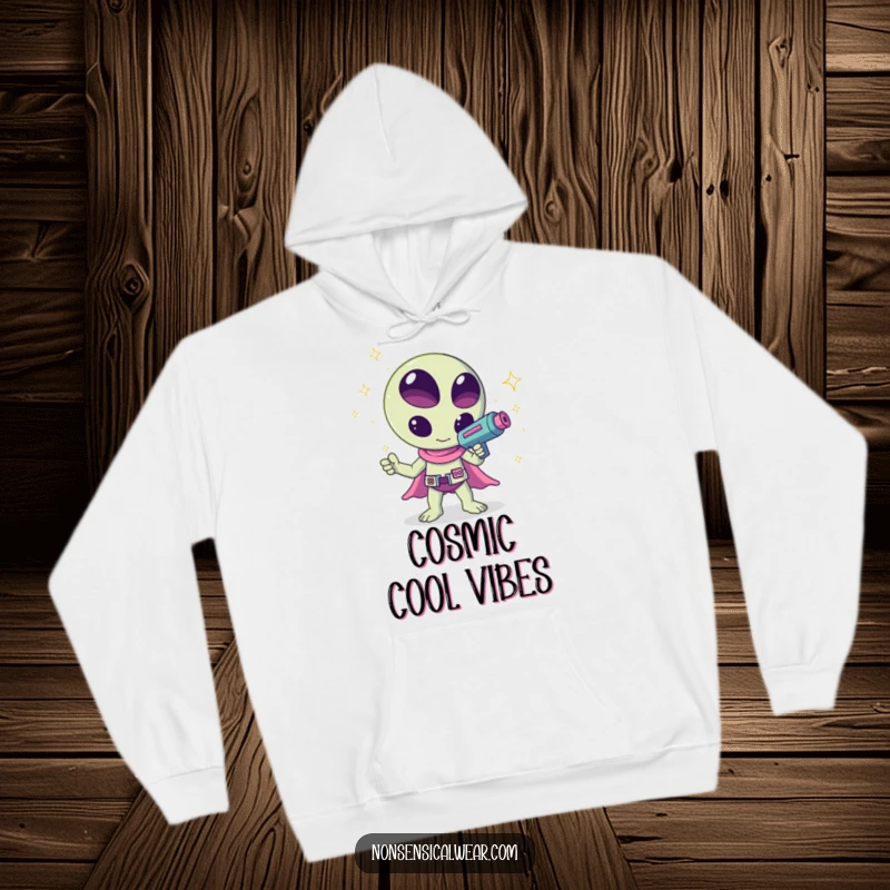 Funny kawaii alien waving a ray gun that shoots sparkles, a humorous and cozy design on this hoodie, ideal for chilling.