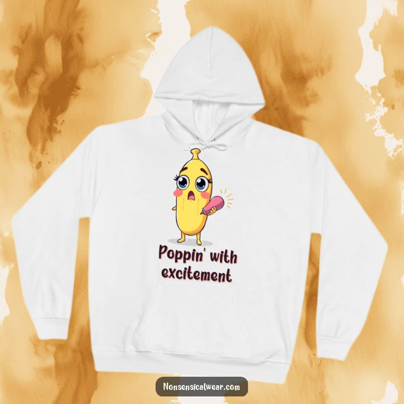 Funny surprised banana character with wide eyes holding a party popper on a soft hoodie, for cozy and surprising humor.